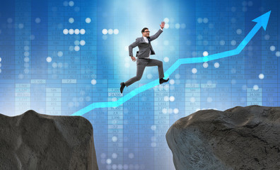 Fototapeta na wymiar Ambitious businessman jumping over the cliff