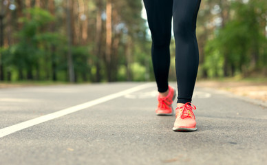 Crop image. Legs of young fitness woman running outdoor.