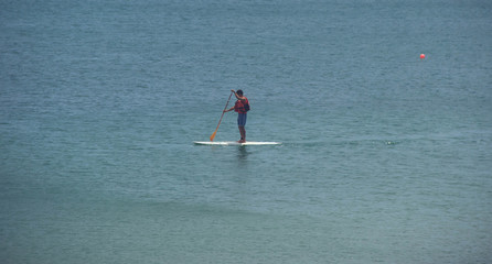 Active surfer on paddle board surfing in ocean.
