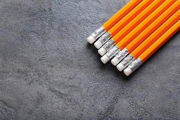 Yellow pencils with erasers on grey wooden table