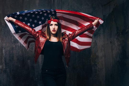 Girl with flying american flag behind the back on dark background. Patriot, national event celebration, pride, usa citizen concept