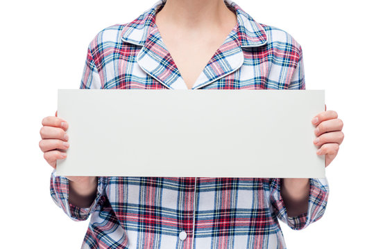 Close-up poster white in the hands of a woman dressed in plaid pajamas