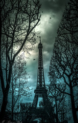 The Eifel tower in clouds at daytime. 
