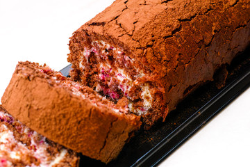 Slices of tasty chocolate sponge cake roll with cream