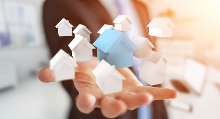 Businessman using 3D rendered small white and blue houses