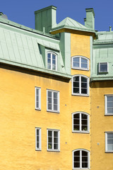 Close up of an apartment building. White windows on a yellow facade.