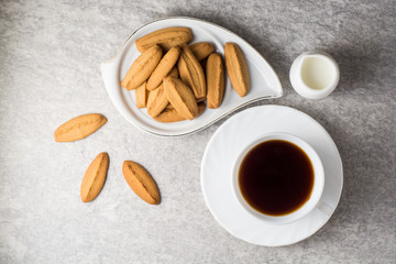 Cup of coffee and ginger cookies on stone table.