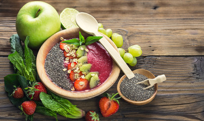 Strawberry smoothie in the bowl with fruits and chia seeds 
