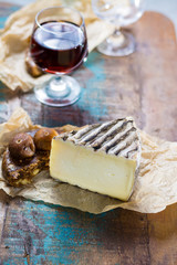 Sweet dessert liqueur wine in glass, hard french cheese Tomme de Montagne and dried figs with figs bread