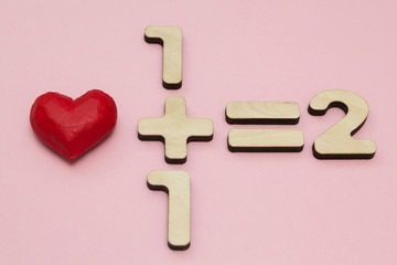 The Mathematics of Love. One plus one equals two. Pink background.