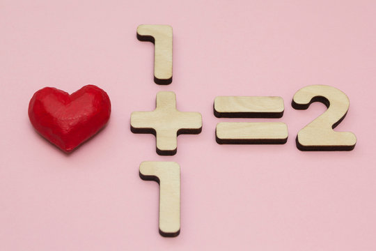 The Mathematics of Love. One plus one equals two. Pink background.