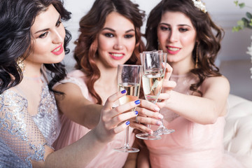 Bachelorette, three girls in pink dresses blue Voile tulle clink glasses of champagne with a smile with joy