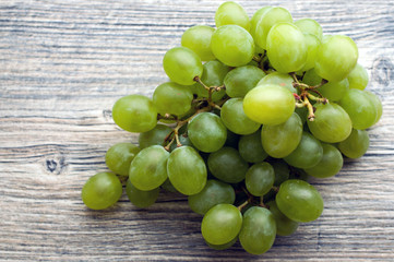 Bunch of green large grapes on a gray board