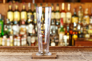 Clean empty glass on the bar counter background