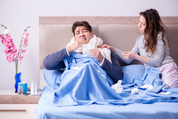 Wife caring for sick husband at home in bed