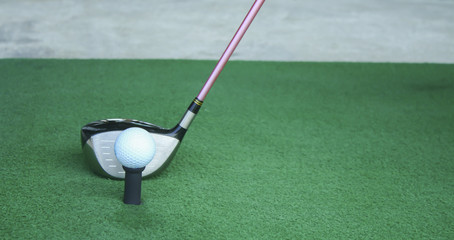 Obraz premium golf ball on tee with driver club, in front of driver, driving range