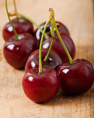 Ripe, sweet cherries on an old wooden background.