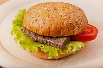 Sandwich with meat, green salad and tomato.
