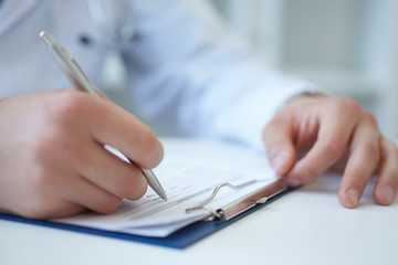 Fototapeta Male medicine doctor hand holding silver pen writing something on clipboard closeup. Ward round, patient visit check, medical calculation and statistics concept. Physician ready to examine patient obraz