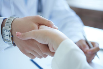 Male doctor shaking hands with patient. Partnership, trust and medical ethics concept. Handshake with satisfied client. Thankful handclasp for excellent treatment.