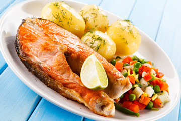 Grilled salmon with potatoes on wooden table