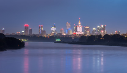 Fototapeta premium Kolorowa noc panorama Warszawska linia horyzontu, Polska, nad Wisłą w nocy