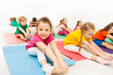 Cute girl stretching on floor in the gym center