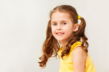 Smiling girl in yellow shirt looking at camera