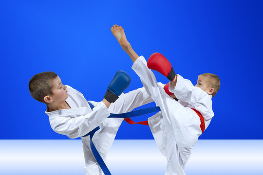 Children athletes are training blows on a light blue background