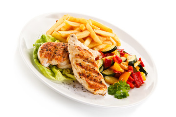 Grilled chicken fillet with french fries on white background