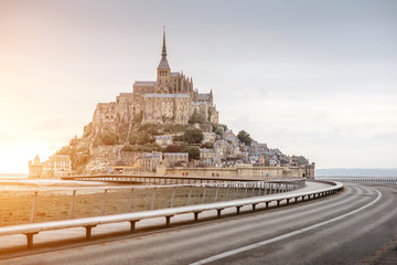 Sunset view on the famous Mont Saint Michel abbey with bridge during the tide in France