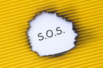SOS word written under torn paper.