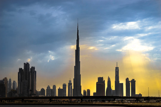 :Panoramic view of business bay, downtown area of Dubai at sunset, dusk. Abstract picture: yellow-black-blue colours.