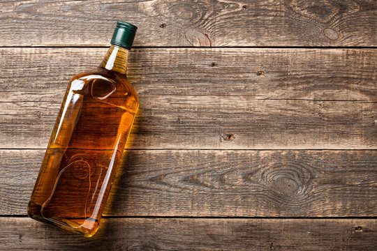 Bottle of whiskey on wooden boards