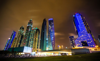 Panoramic view on night highlighted luxury Dubai Marina with bridge on the foreground and skyscrapers on the background ,Dubai,United Arab Emirates.