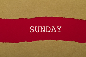 Sunday word written under torn paper.