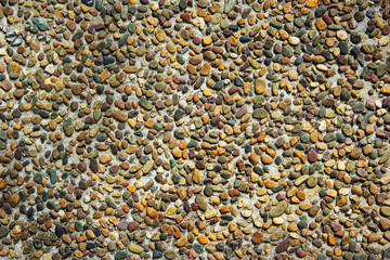 Background of small natural stones in concrete. Wall with natural stone. Stucco with stones.