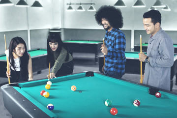 Multiracial people playing billiard