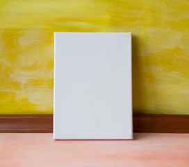 Mock up poster in the interior. Blank canvas against the yellow wooden wall.