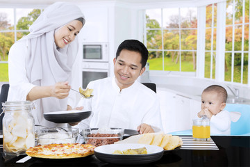 Muslim female serves meal in dining table