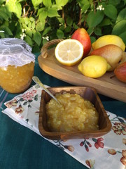 Jam in a glass jar. Confiture of pears with lemon in a wooden bowl.