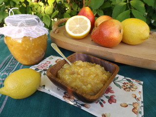 Jam in a glass jar. Confiture of pears with lemon in a wooden bowl.
