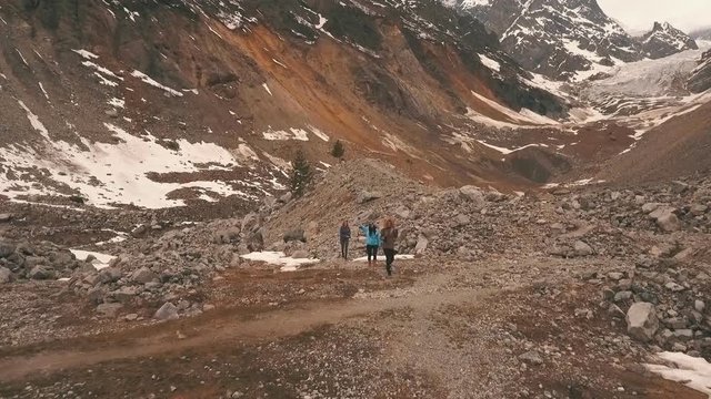 the group of travelers in the mountains waving to the camera