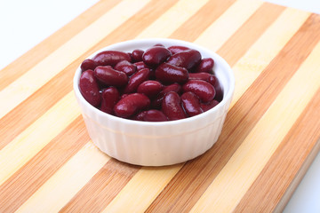Heap of canned red kidney beans in the sauce in white bowl. vegetarian food. Phaseolus vulgaris.
