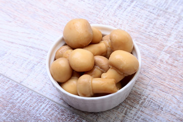 Marinated champignons in white bowl. ready for cooking.