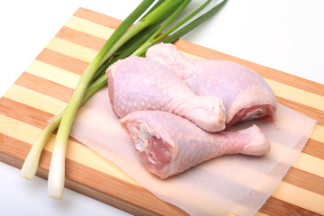 raw chicken legs with spices on a wooden board. Ready for cooking.
