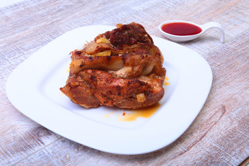Steak of grilled meat with red sauce on white plate.
