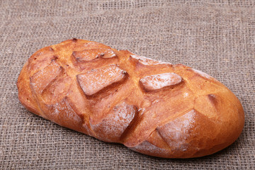 Fresh homemade bread on Sackcloth woven texture background. Selective focus.