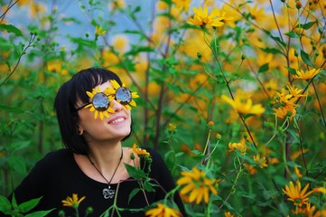 Wonderful portrait of cheerful smiling young brunette woman in sunglasses, out of which Peeps the...