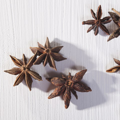 Star shaped anise seeds on a white wooden background